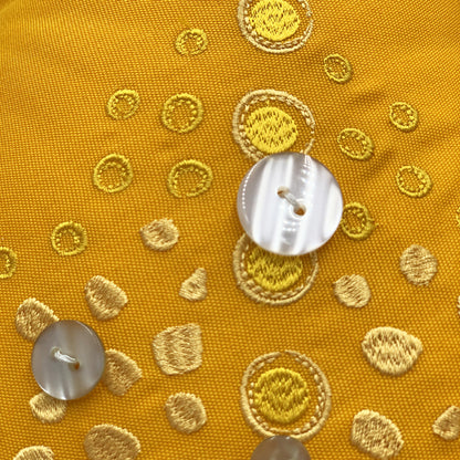 Detail shot of the embroidery work and beaded accents of the Marigold Sea Star Shaped Pillow.