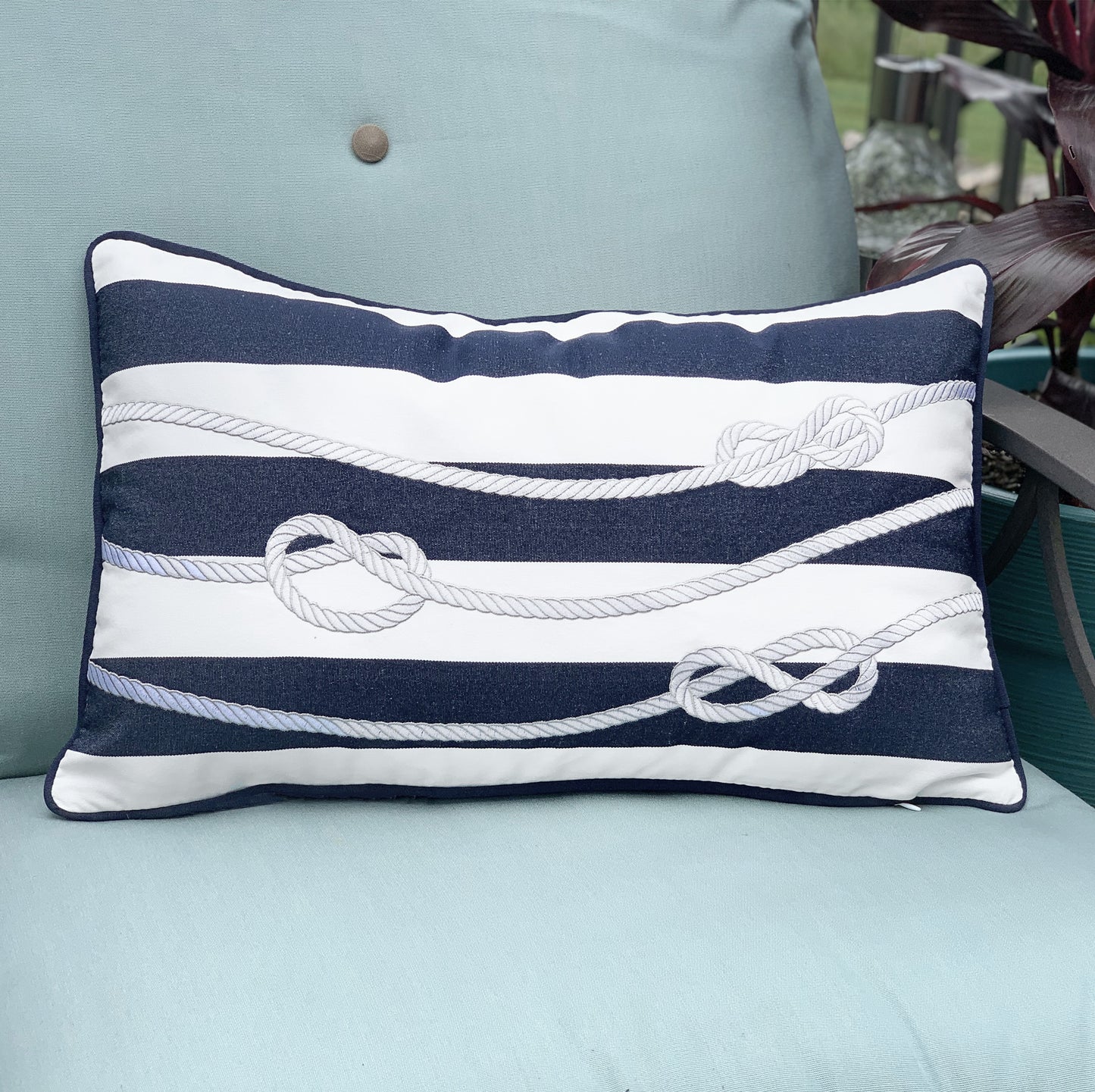 Navy and White Rope Indoor Outdoor Pillow styled on an outdoor patio chair.