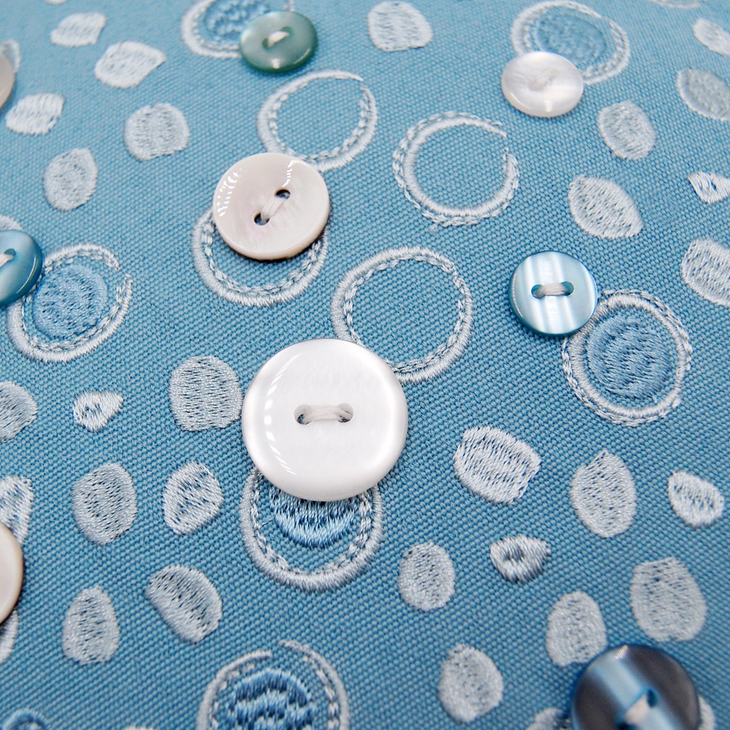 Detail shot of the embroidery work and beaded accents on the Oceana Sea Star Shaped pillow.