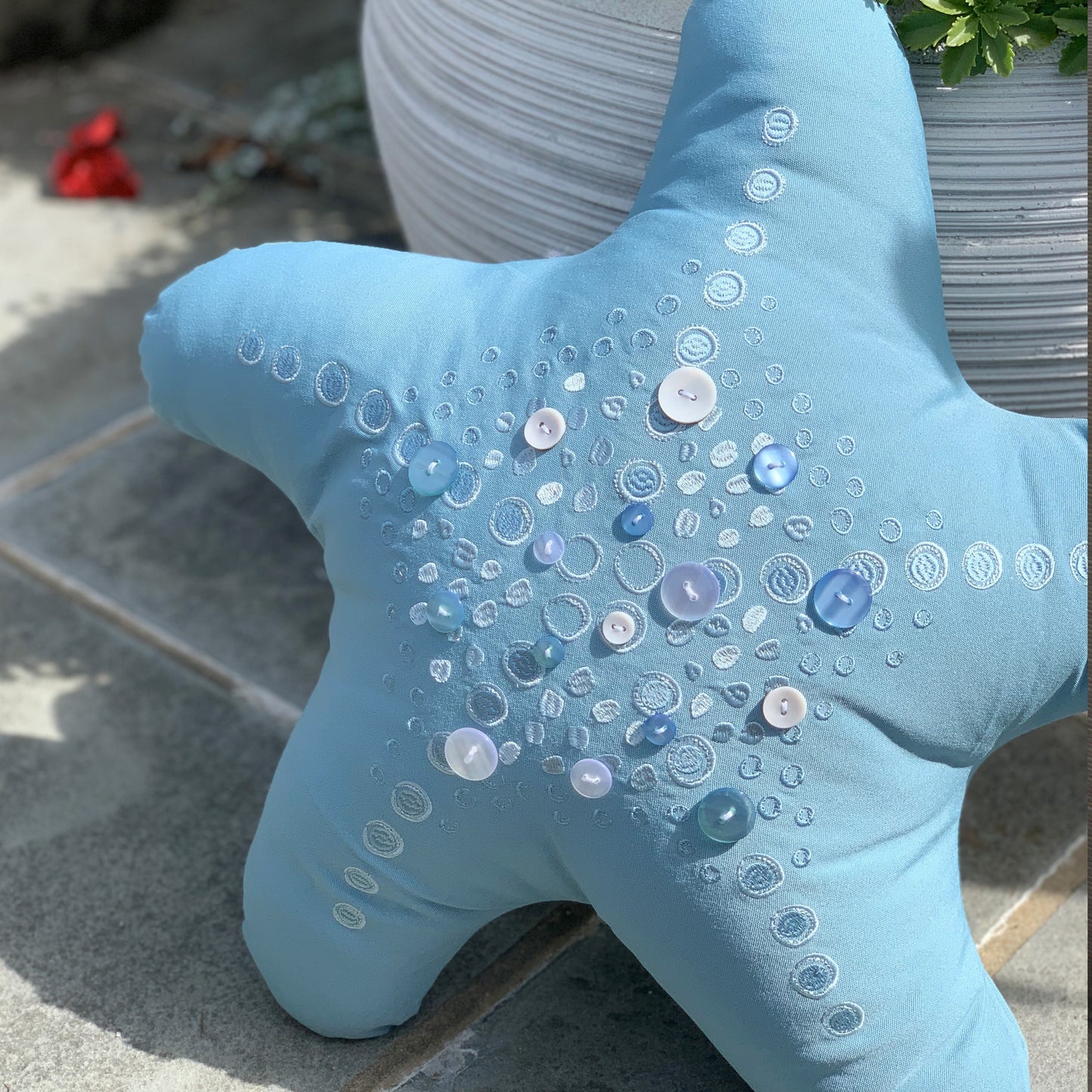 Oceana Shaped Star Fish pillow styled on an outdoor patio.