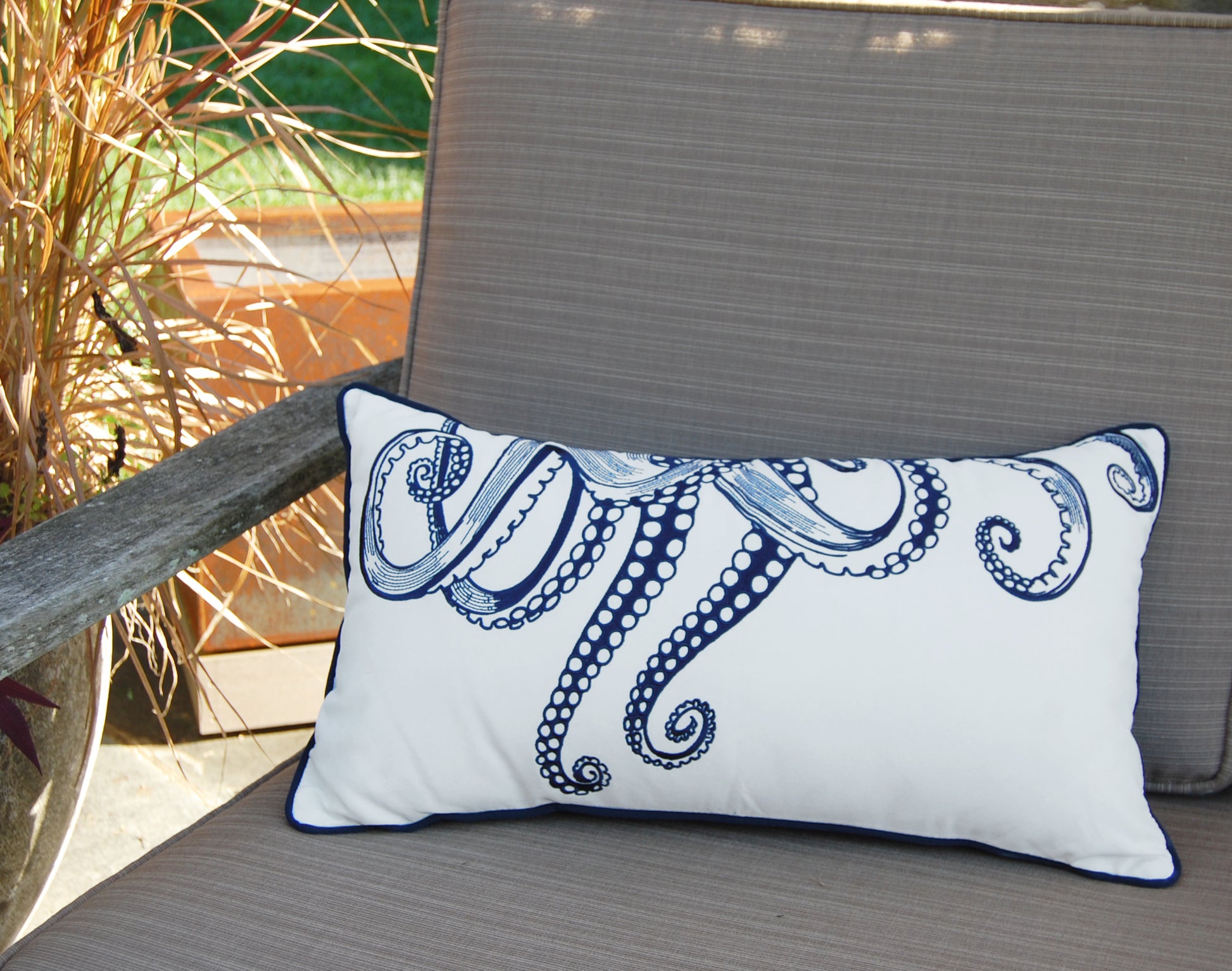 Octopus Tentacles Indoor Outdoor pillow styled on an outdoor patio chair.