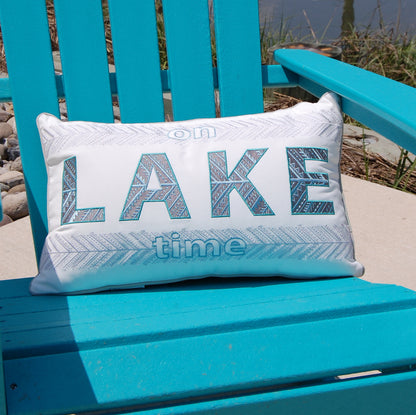 One Lake Time Indoor Outdoor pillow styled on a teal Adirondack chair.