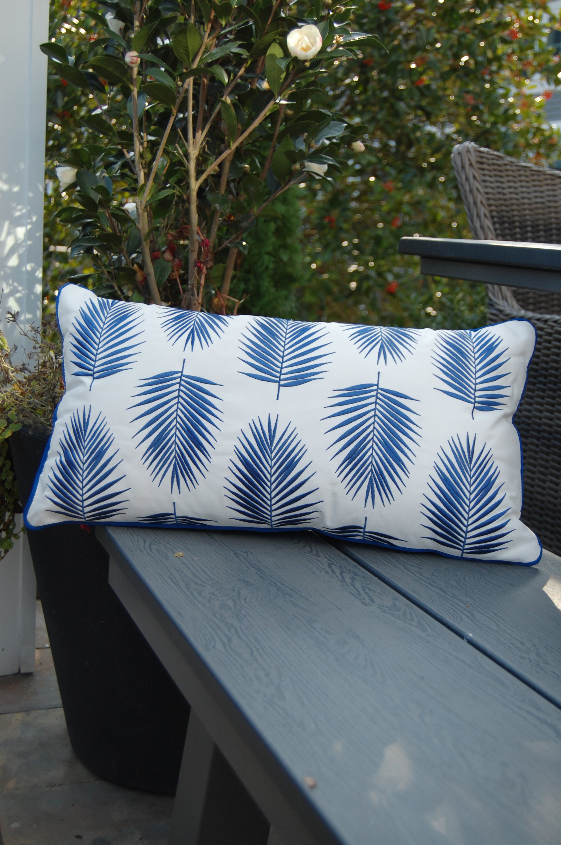 Palm Pattern Lumbar Indoor Outdoor Pillow styled on a bench.