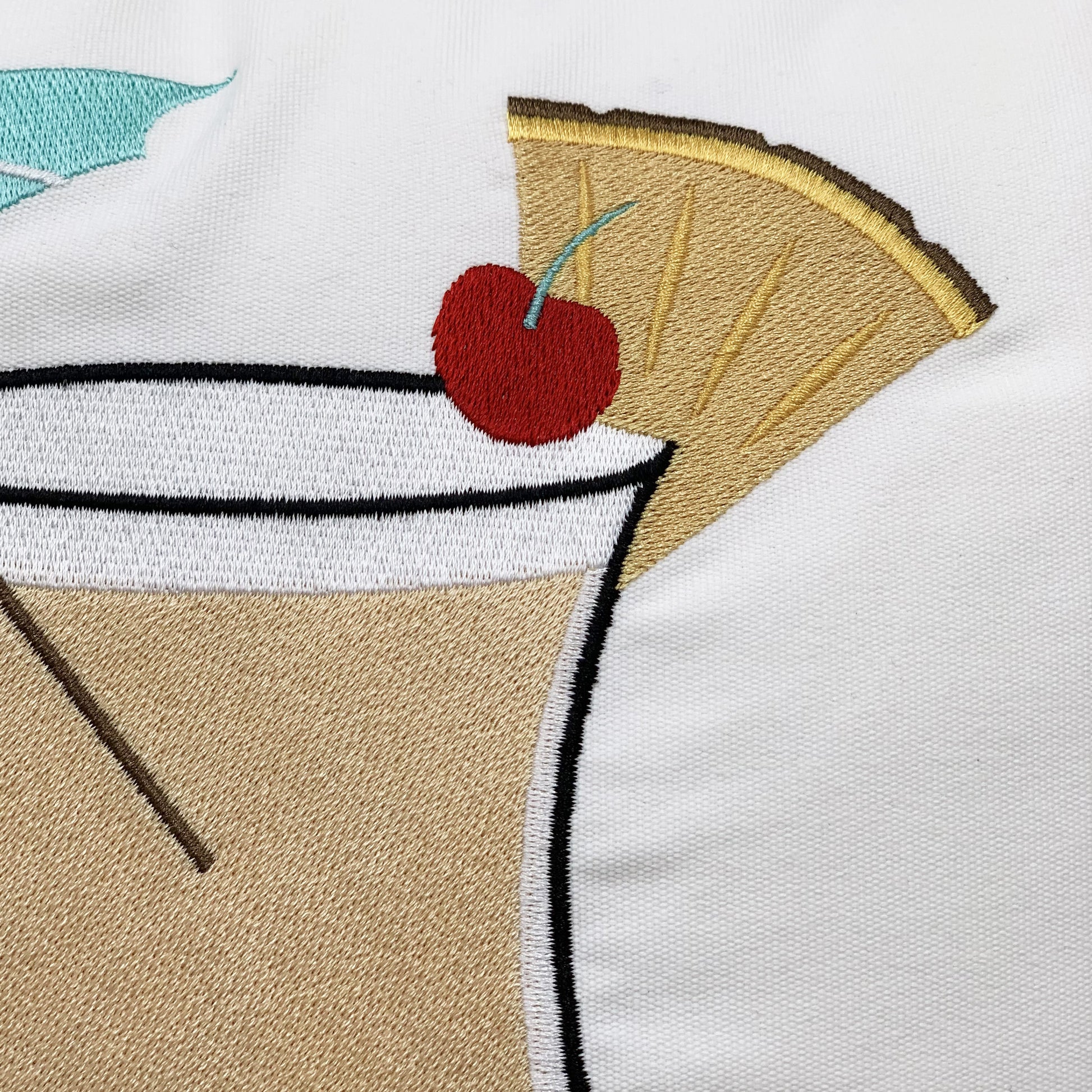 Detailed shot of the Pina Colada Indoor Outdoor Pillow's embroidery work.