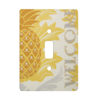 ceramic single toggle switch plate featuring a pineapple and text that reads "welcome". also featuring white and grey decorative accents in the background.