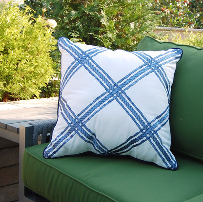 Rope Lattice White Indoor Outdoor Pillow styled on a green patio chair.