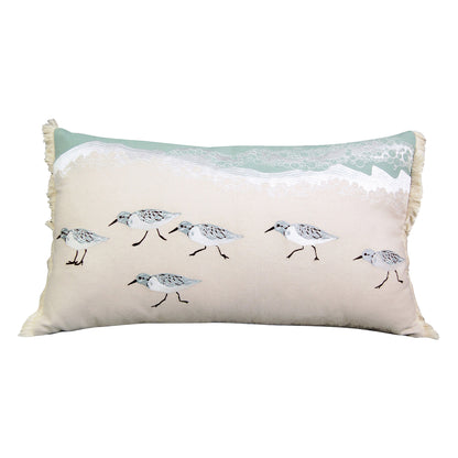 A family of sand piper birds walking along the shoreline embroidered on a lumbar pillow. 