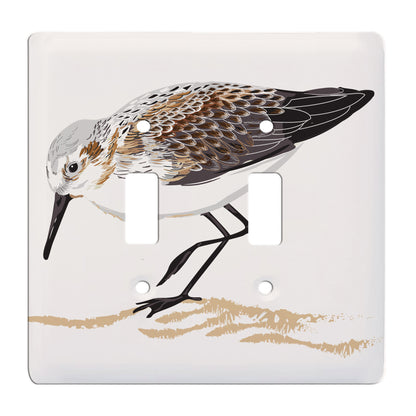 ceramic double toggle switch plate featuring a sandpiper on the sand.