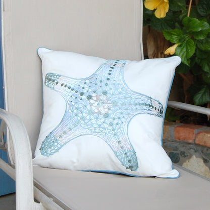 Sea Glass Sea Star Indoor Outdoor pillow styled on a patio chair.