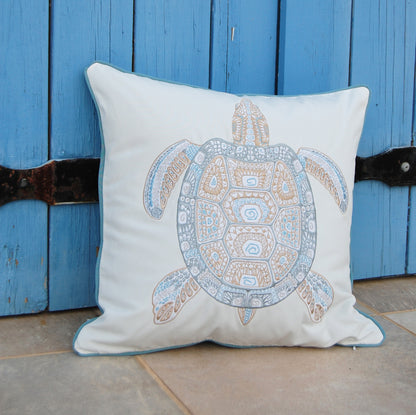 Sea Glass Tribal Turtle Indoor Outdoor Pillow styled on a patio.