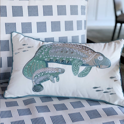 Seaglass Tribal Manatee Indoor Outdoor Pillow styled on a patio chair.