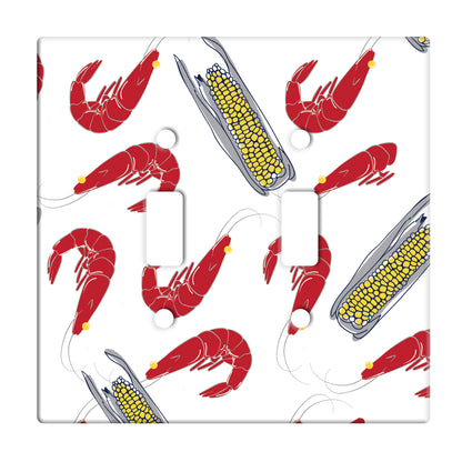 white ceramic double toggle switch plate featuring shrimp and corn on the cob. 