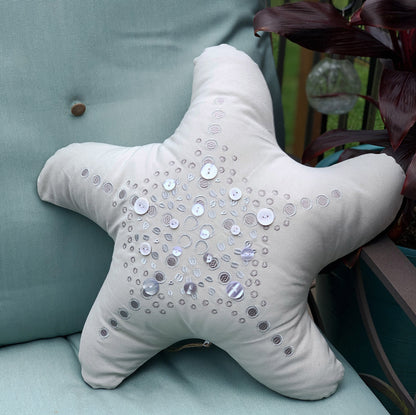 Silver Shaped Sea Star pillow styled on an outdoor patio chair.