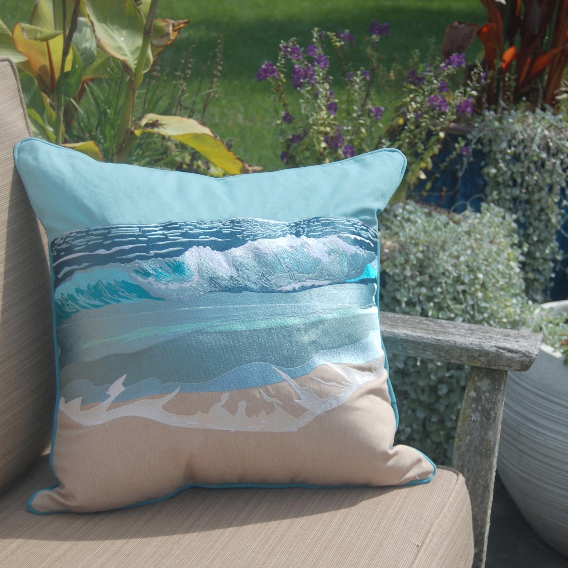 Surf Breaker Indoor Outdoor Pillow styled on a garden chair.