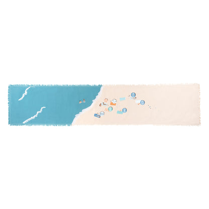 Colorful beach umbrellas, towels, and sun bathers embroidered on a sandy beach scene of natural and blue cotton on a fringed table runner.