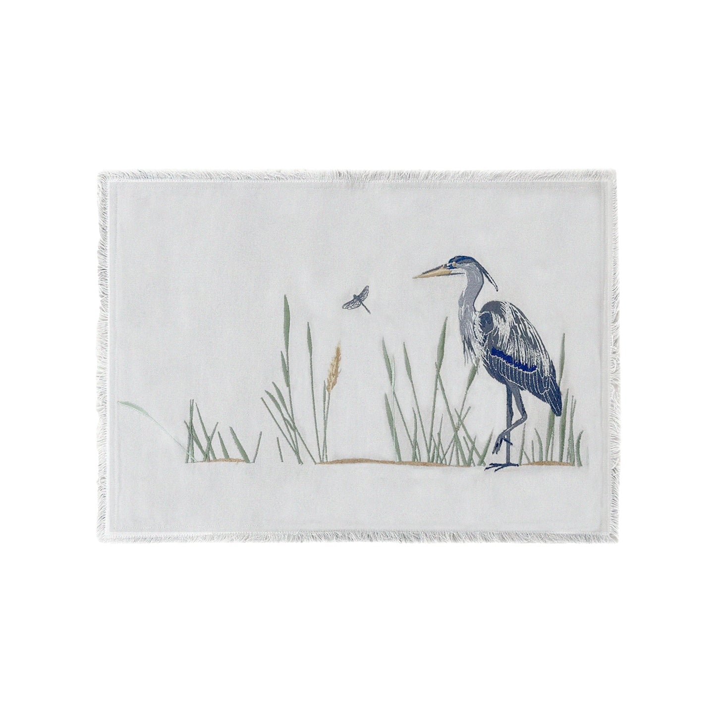 Grey cotton fringed placemat featuring embroidery of Great Blue Heron and reeds. 