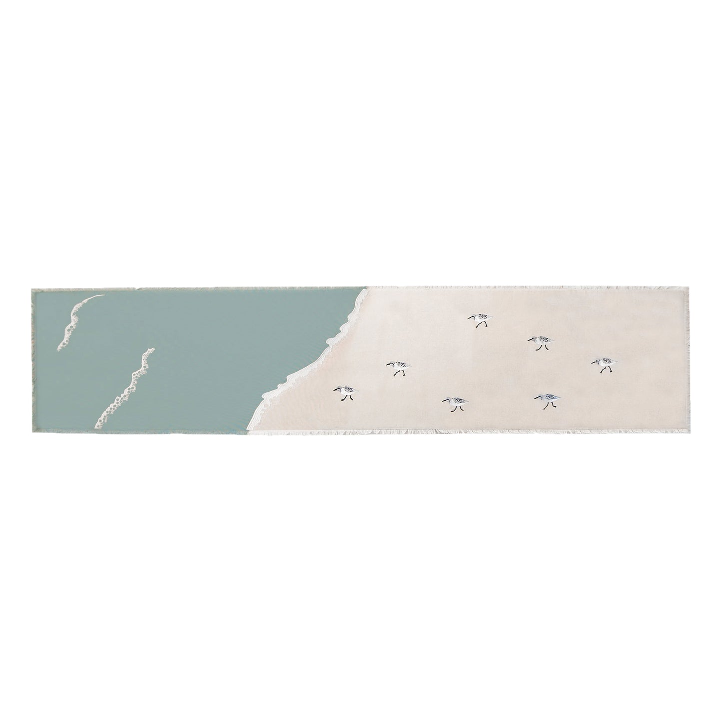 Sandpipers embroidered on a cotton fringed table runner featuring blue waves on sand. 