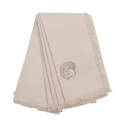 A natural cotton fringed napkin featuring an embroidered scallop shell.