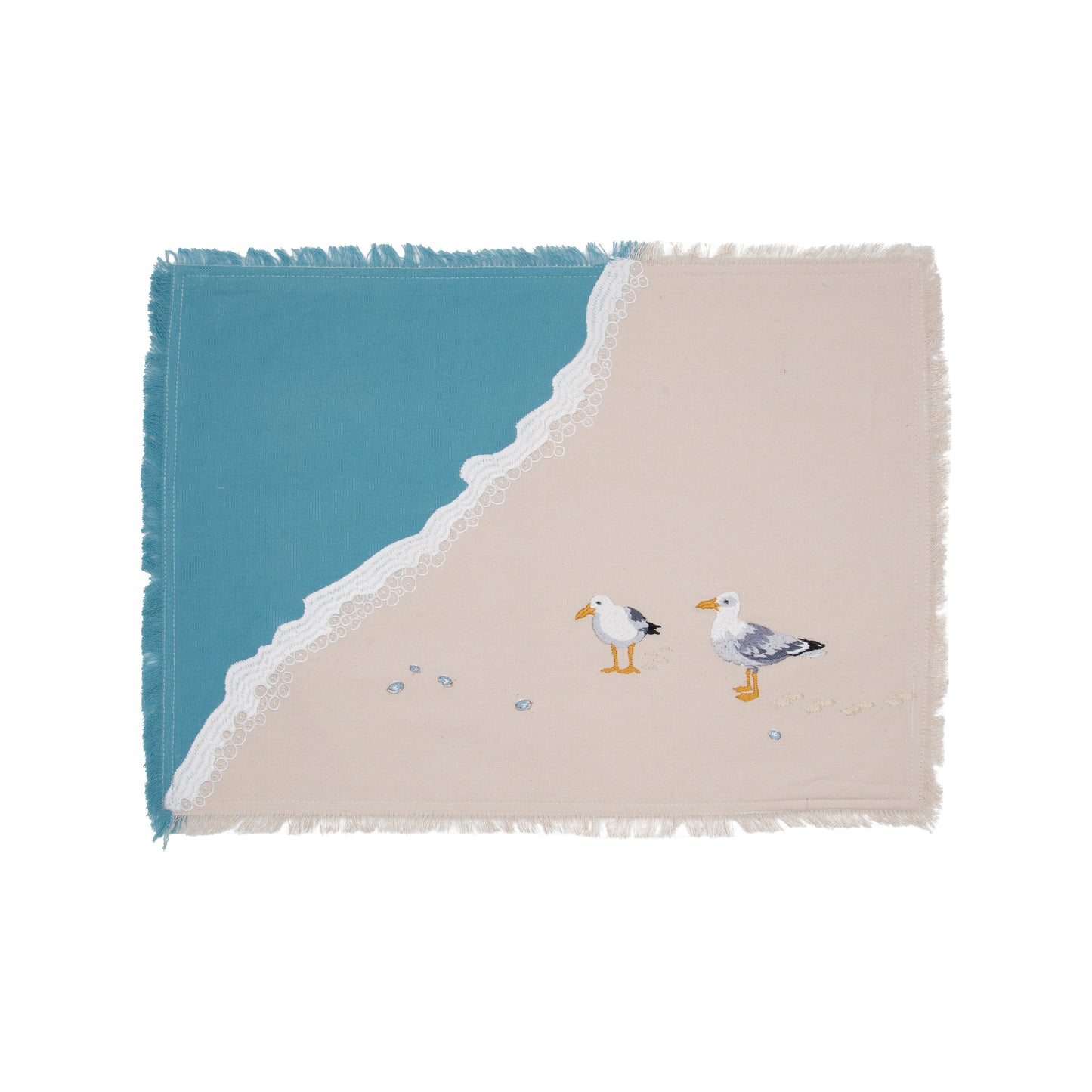 Two sea gulls embroidered on a cotton fringed placemat featuring blue waves on sand.