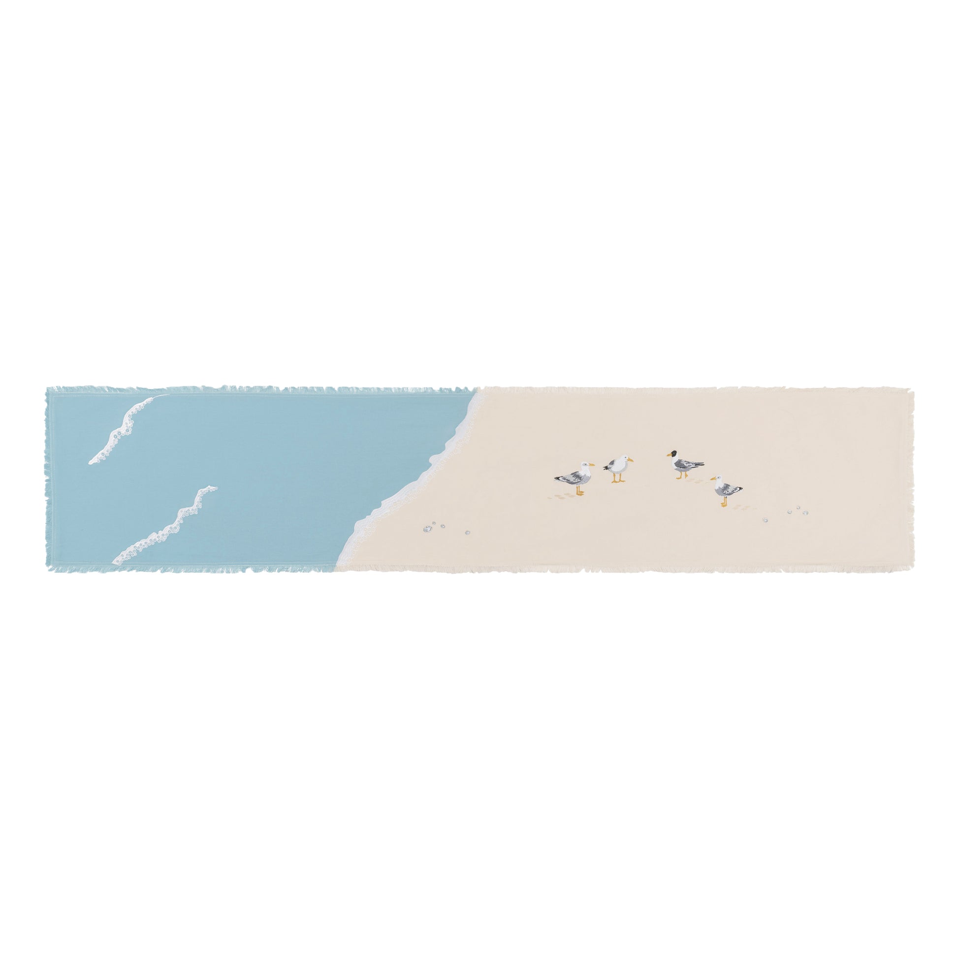 Sea gulls embroidered on a cotton fringed table runner featuring blue waves on sand.